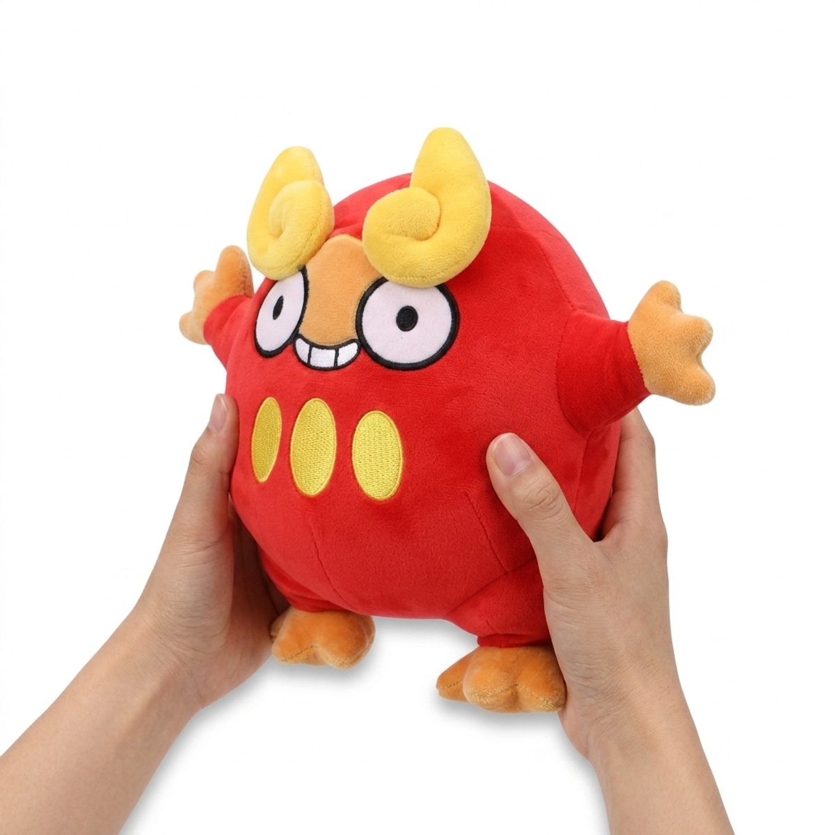 Peluche Darumaka tenuto nelle mani