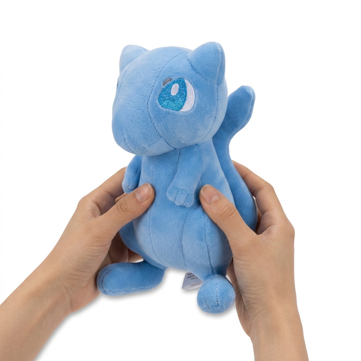 Peluche Mew Shiny tenuto nelle mani